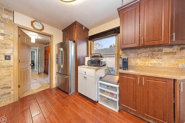 kitchen with decorative backsplash, stainless steel fridge, and dark wood-type flooring