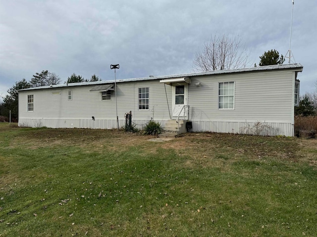 rear view of property with a yard