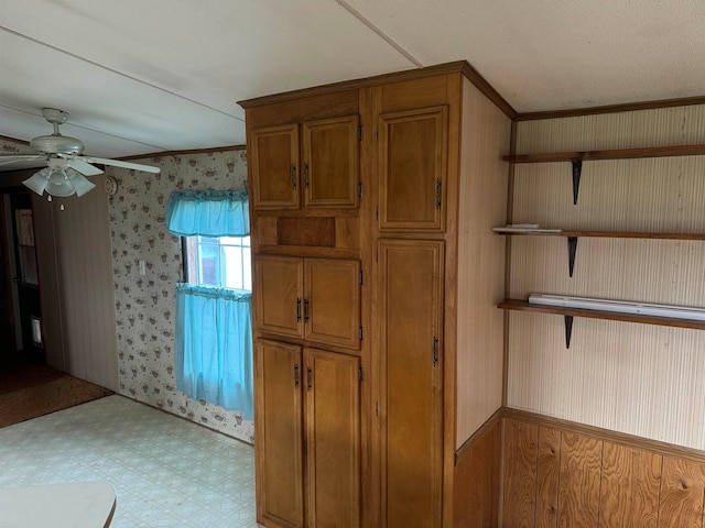 interior space featuring ceiling fan and crown molding