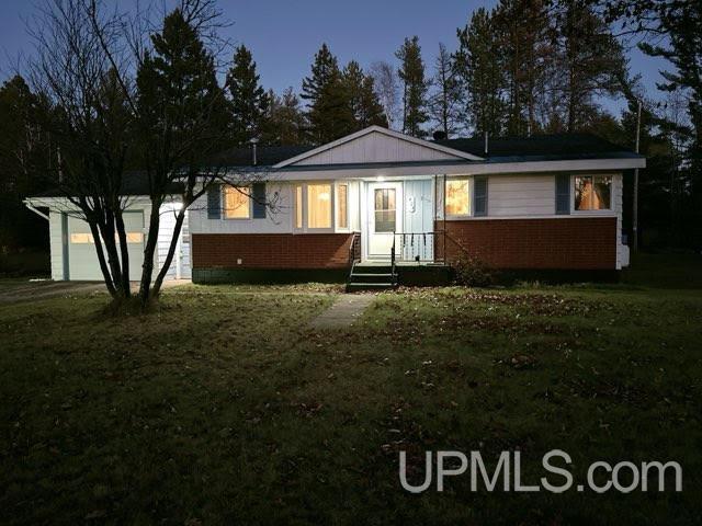 ranch-style home with a yard and a garage