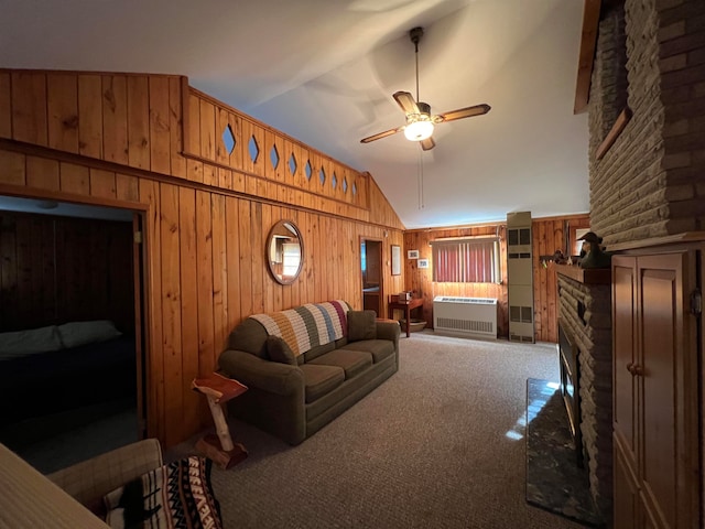 carpeted living room with a fireplace, high vaulted ceiling, ceiling fan, and wooden walls