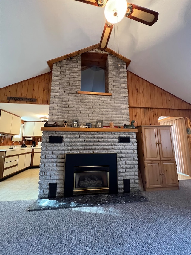 unfurnished living room with wood walls, lofted ceiling, and a brick fireplace