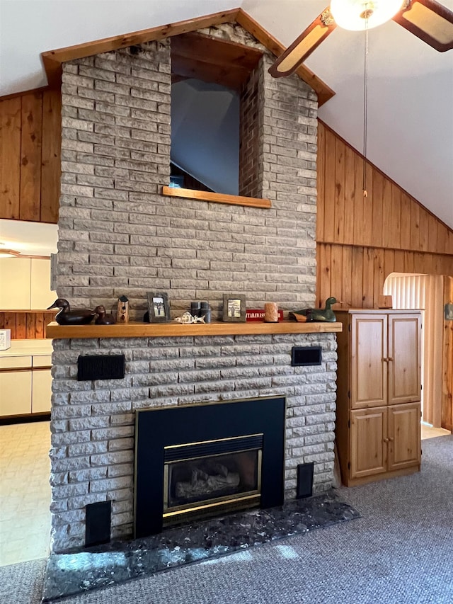 details with a brick fireplace, ceiling fan, and wood walls