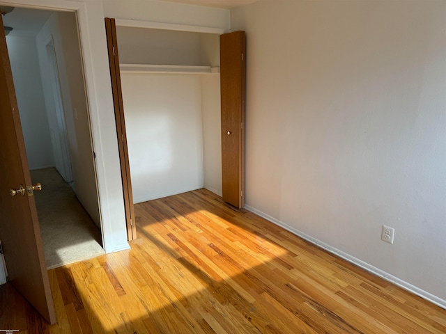 unfurnished bedroom featuring a closet and light hardwood / wood-style flooring