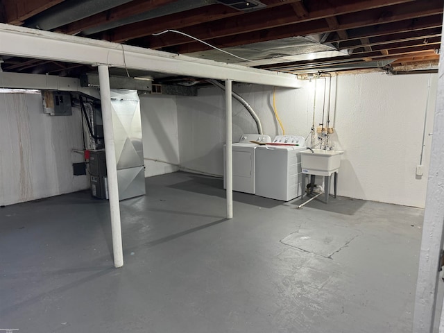 basement with heating unit, sink, and independent washer and dryer