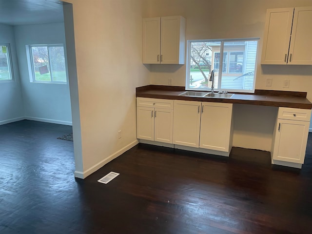 kitchen with white cabinets, plenty of natural light, dark wood-type flooring, and sink