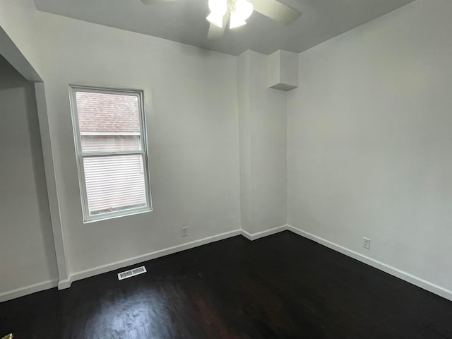 empty room featuring dark hardwood / wood-style flooring and ceiling fan