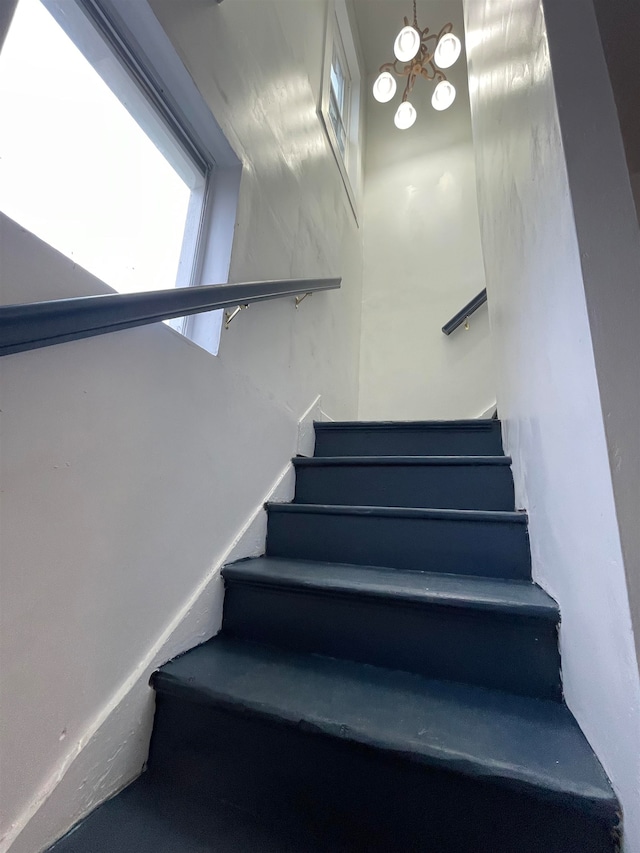 stairs featuring an inviting chandelier