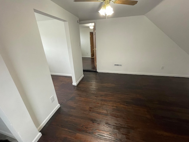 additional living space with ceiling fan, dark hardwood / wood-style flooring, and vaulted ceiling