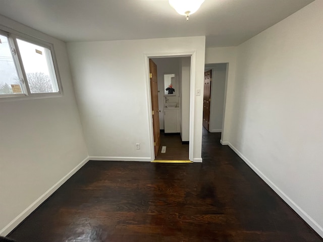 unfurnished room with dark wood-type flooring