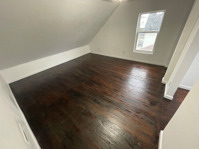 additional living space with dark hardwood / wood-style flooring and lofted ceiling