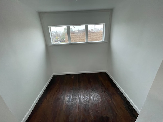 unfurnished room featuring dark wood-type flooring