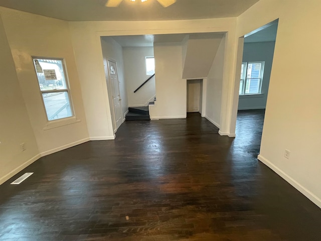 spare room featuring dark hardwood / wood-style flooring, ceiling fan, and plenty of natural light