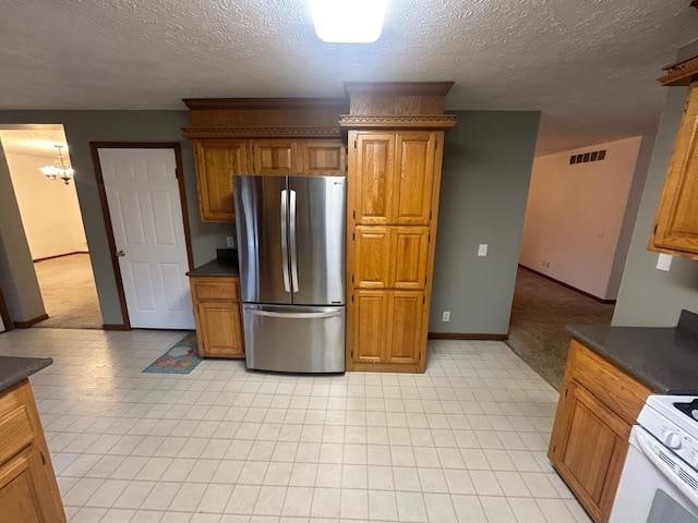 kitchen featuring a chandelier, stainless steel fridge, a textured ceiling, and white electric range oven