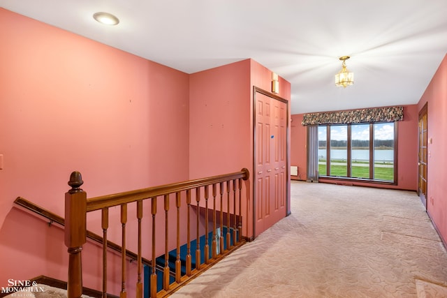 hallway featuring a water view and light colored carpet