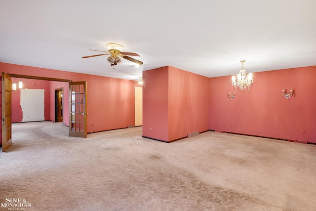 unfurnished room featuring light colored carpet and ceiling fan with notable chandelier