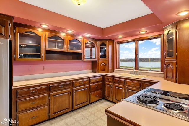 kitchen with stainless steel fridge, sink, and a water view