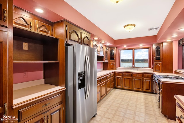 kitchen with sink and stainless steel refrigerator with ice dispenser