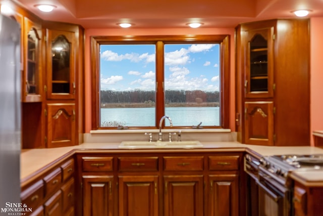 kitchen featuring a water view, sink, and stainless steel stove