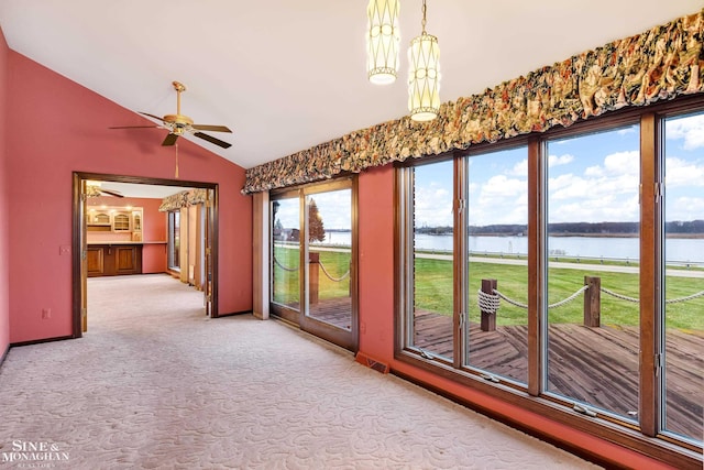 interior space with ceiling fan, a healthy amount of sunlight, a water view, and lofted ceiling