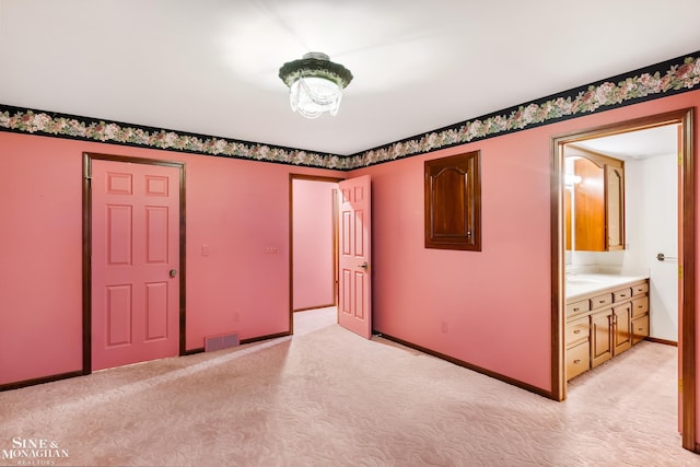 interior space with light colored carpet, sink, and connected bathroom