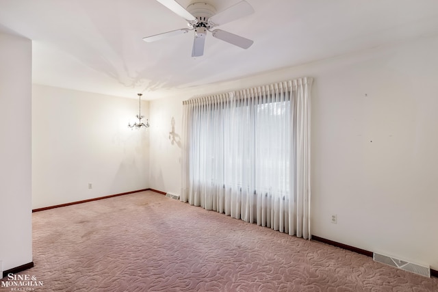 unfurnished room with carpet flooring and ceiling fan with notable chandelier