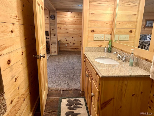 bathroom with tile patterned flooring, vanity, and wood walls