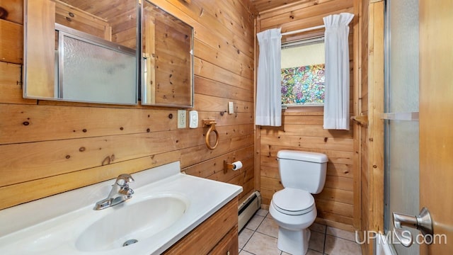 bathroom with tile patterned floors, vanity, baseboard heating, wooden walls, and toilet