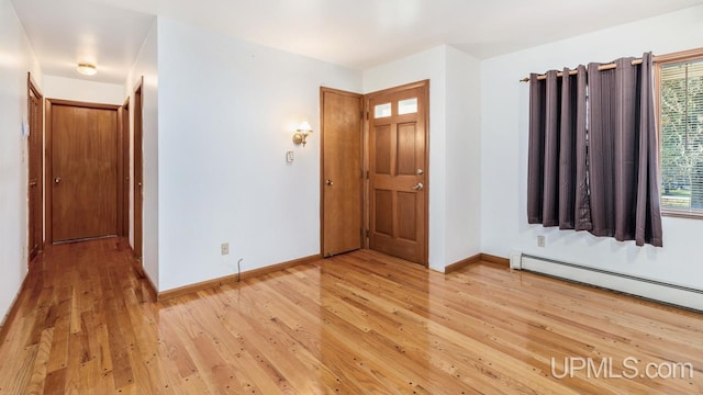 interior space featuring baseboard heating and hardwood / wood-style floors