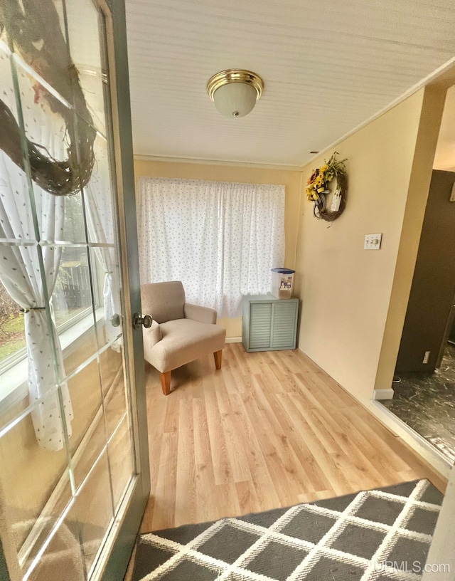 living area featuring hardwood / wood-style floors, ornamental molding, and french doors