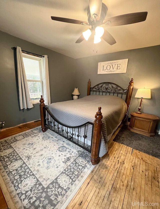 bedroom with ceiling fan and hardwood / wood-style flooring