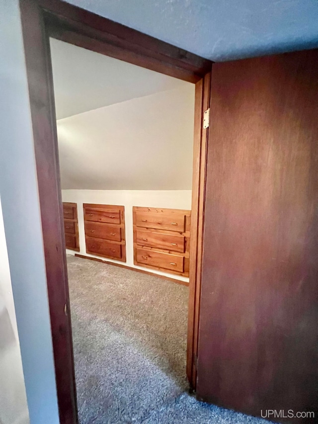 hall featuring carpet flooring and lofted ceiling with beams