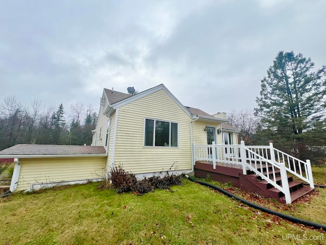 back of house featuring a lawn and a wooden deck