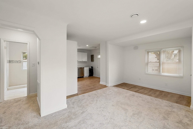 unfurnished living room featuring plenty of natural light and light hardwood / wood-style floors