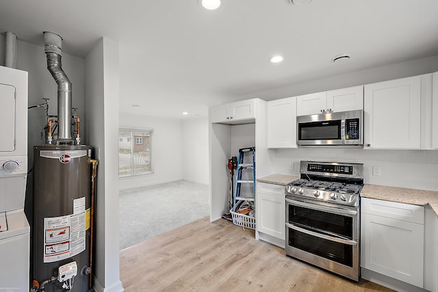 kitchen featuring light stone countertops, stainless steel appliances, water heater, light hardwood / wood-style flooring, and white cabinets