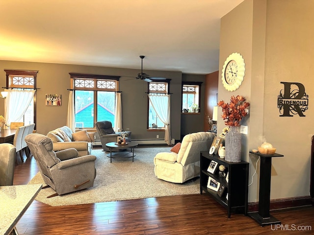 living room with baseboard heating, ceiling fan, and dark wood-type flooring