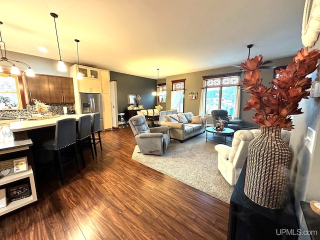 living room with dark hardwood / wood-style flooring and an inviting chandelier