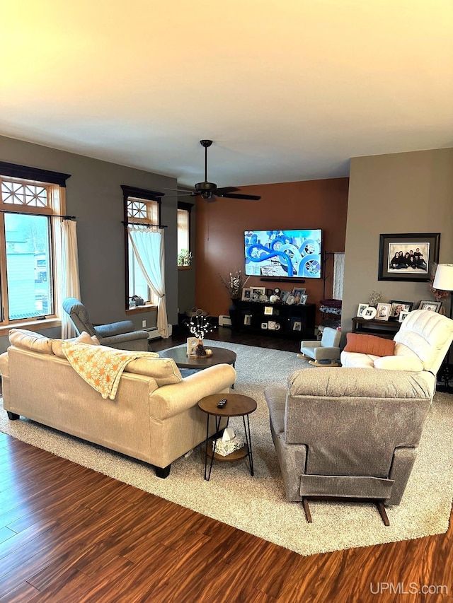 living room featuring wood-type flooring, a baseboard radiator, and ceiling fan