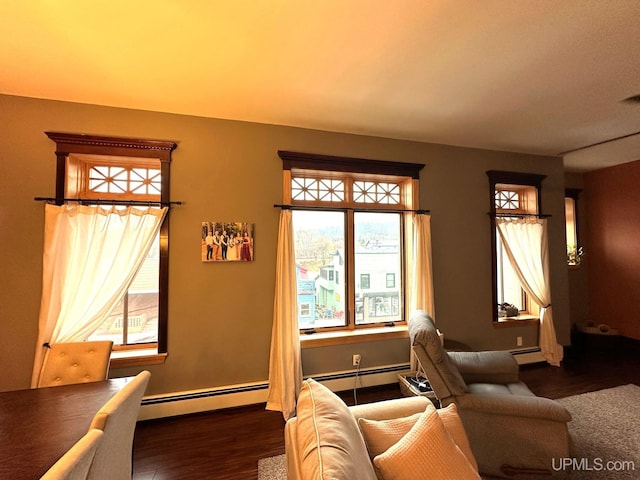 living room with baseboard heating, plenty of natural light, and dark wood-type flooring