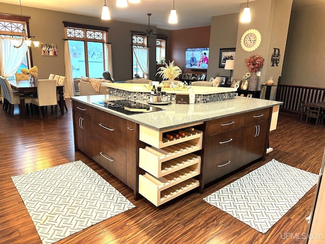 kitchen with black electric stovetop, dark brown cabinetry, dark hardwood / wood-style floors, and a kitchen island