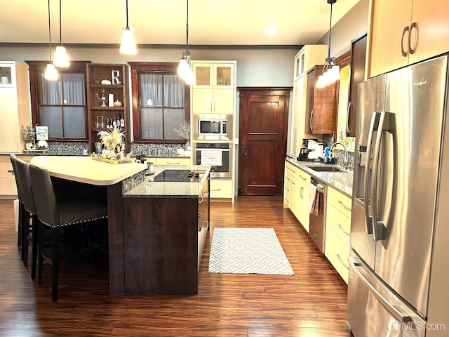 318 Iron St, Negaunee, MI 49866 - kitchen with appliances with stainless steel finishes, a sink, a kitchen island, dark wood-style floors, and crown molding