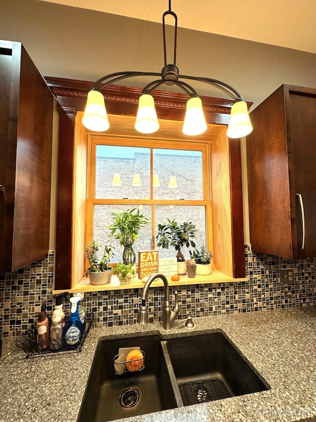 kitchen with backsplash, stone countertops, sink, and a wealth of natural light