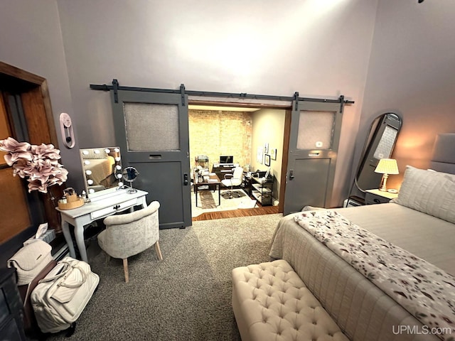 bedroom featuring carpet, a barn door, and a towering ceiling