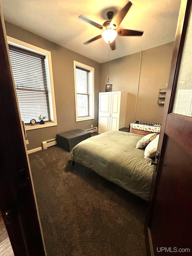 carpeted bedroom with ceiling fan and a baseboard heating unit