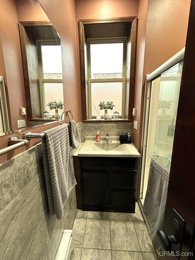 318 Iron St, Negaunee, MI 49866 - bathroom with a shower stall, healthy amount of natural light, decorative backsplash, and vanity