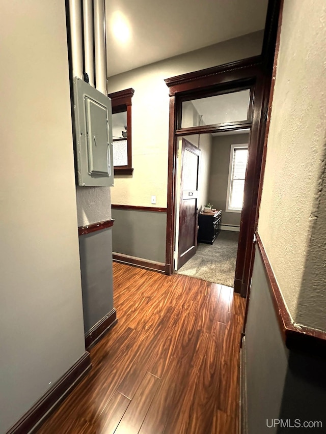 hall featuring baseboard heating, dark wood-type flooring, and electric panel