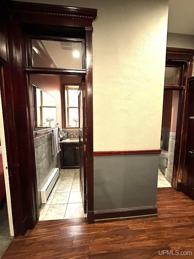 hall featuring light hardwood / wood-style flooring and a baseboard heating unit