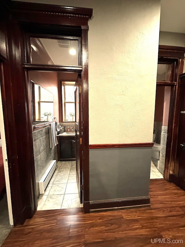 318 Iron St, Negaunee, MI 49866 - hall featuring baseboard heating, light wood-style flooring, and a textured wall