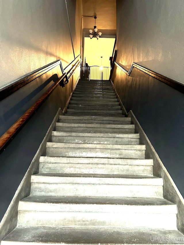 staircase with a chandelier