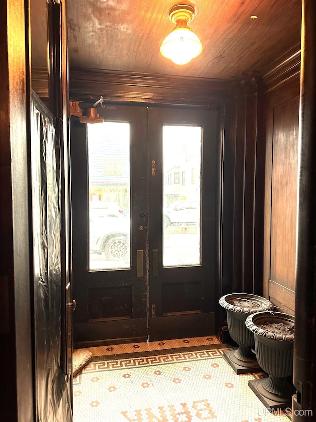 foyer with french doors, wooden walls, and wood ceiling